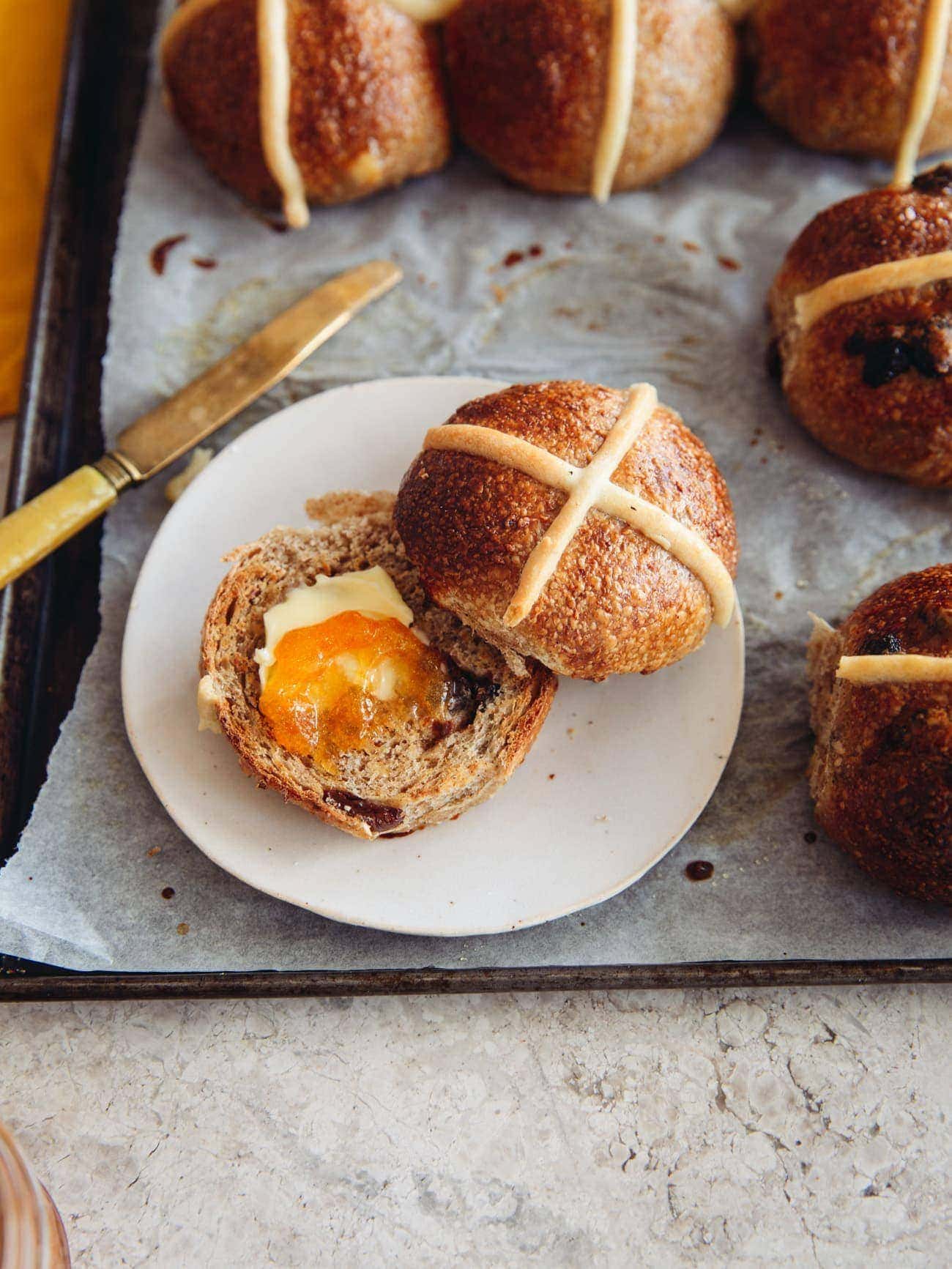 A toasted Sourdough Hot Cross Bun with butter and jam by Izy Hossack