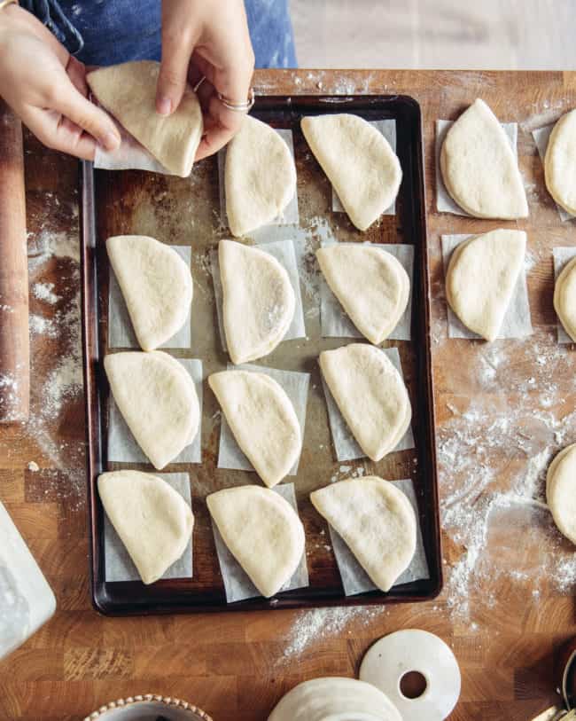 Placing shaped bao buns onto a baking tray