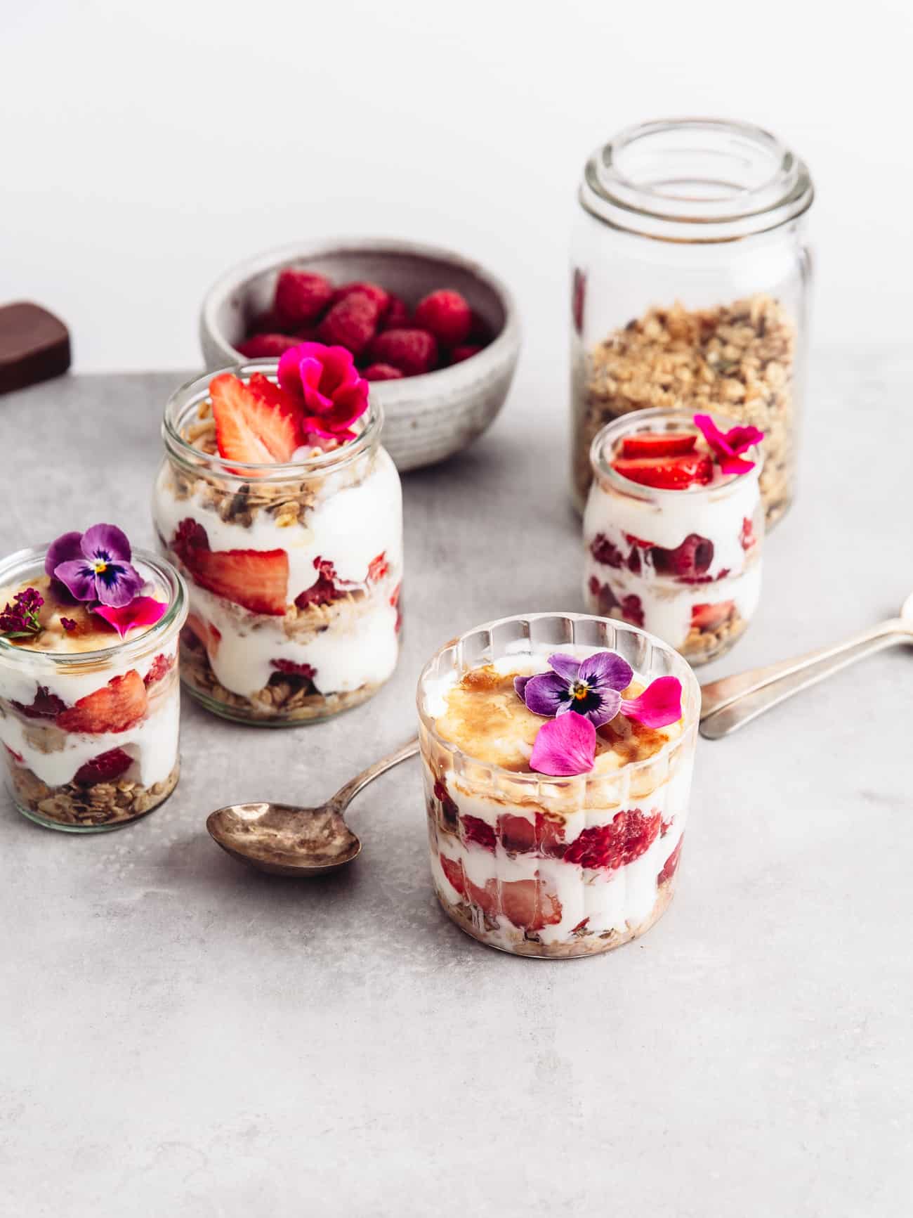Three jars of layered yoghurt with brulee tops, fruit and granola