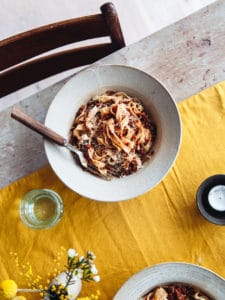 A bowl of tagliatelle with lentil ragu on a table