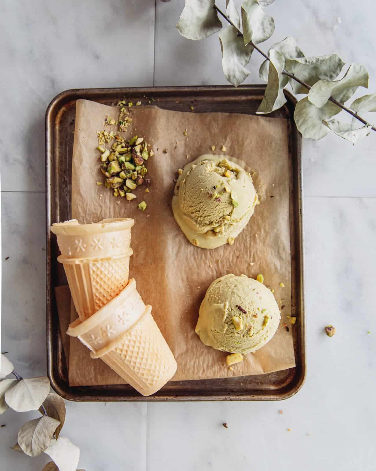 a tray with 2 scoops of pistachio ice cream and 2 ice cream cones