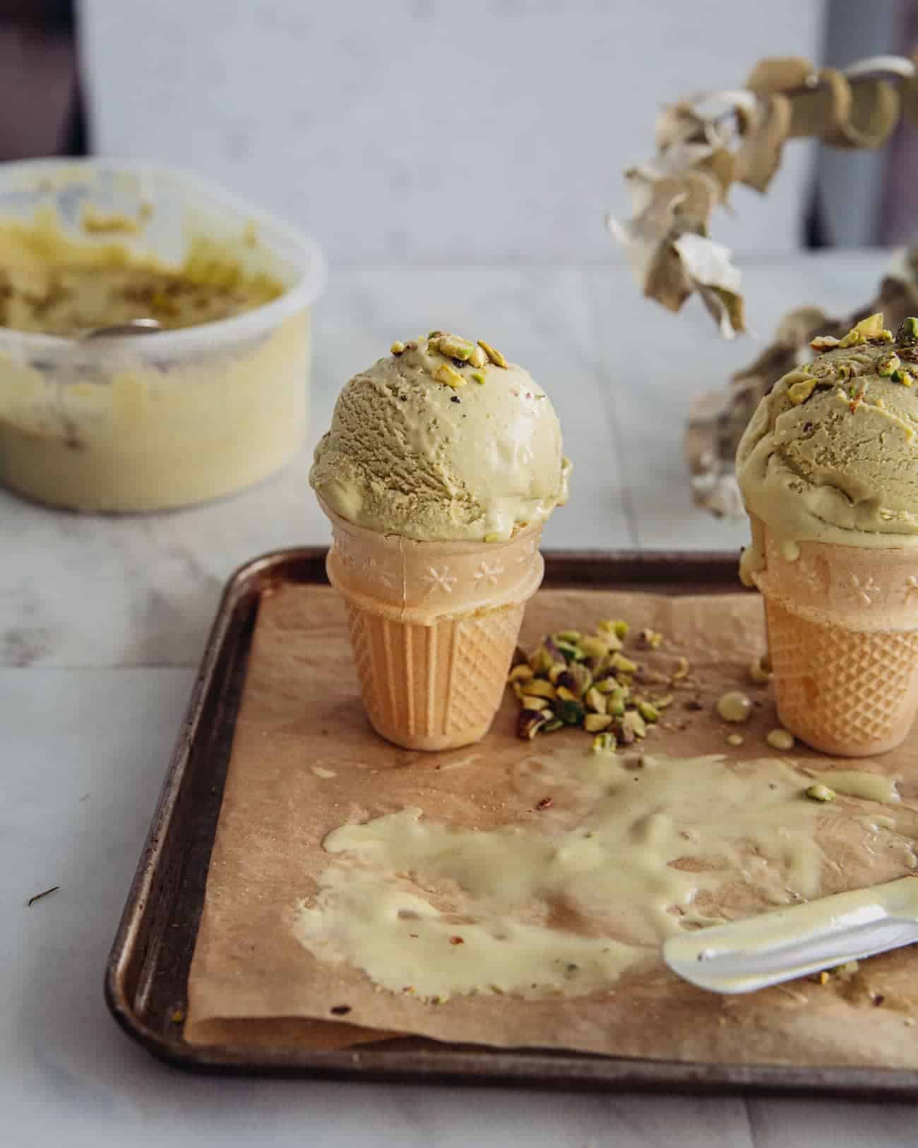 two ice cream cones with pistachio ice cream