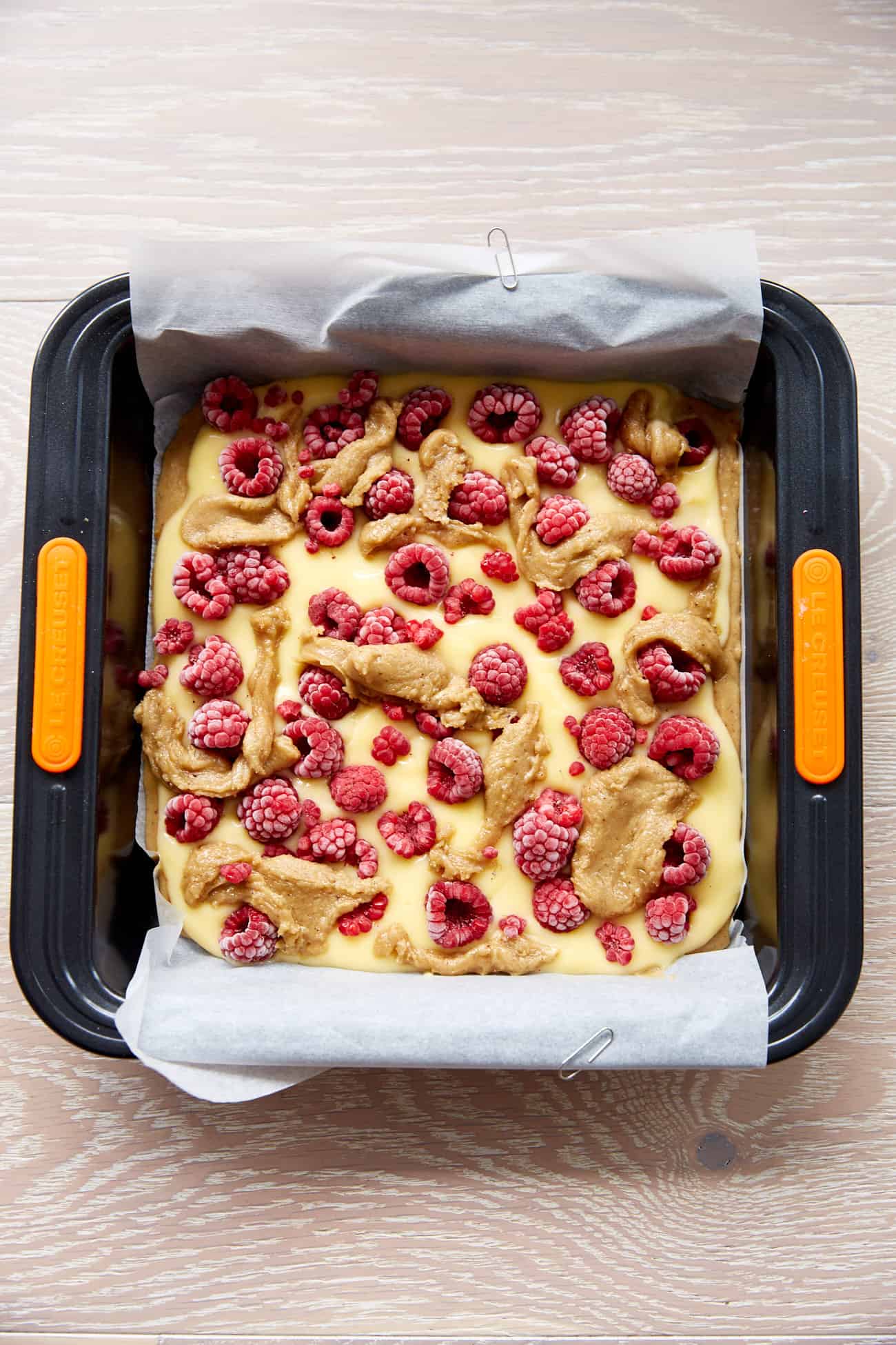 unbaked raspberry and custard blondies in a baking tray