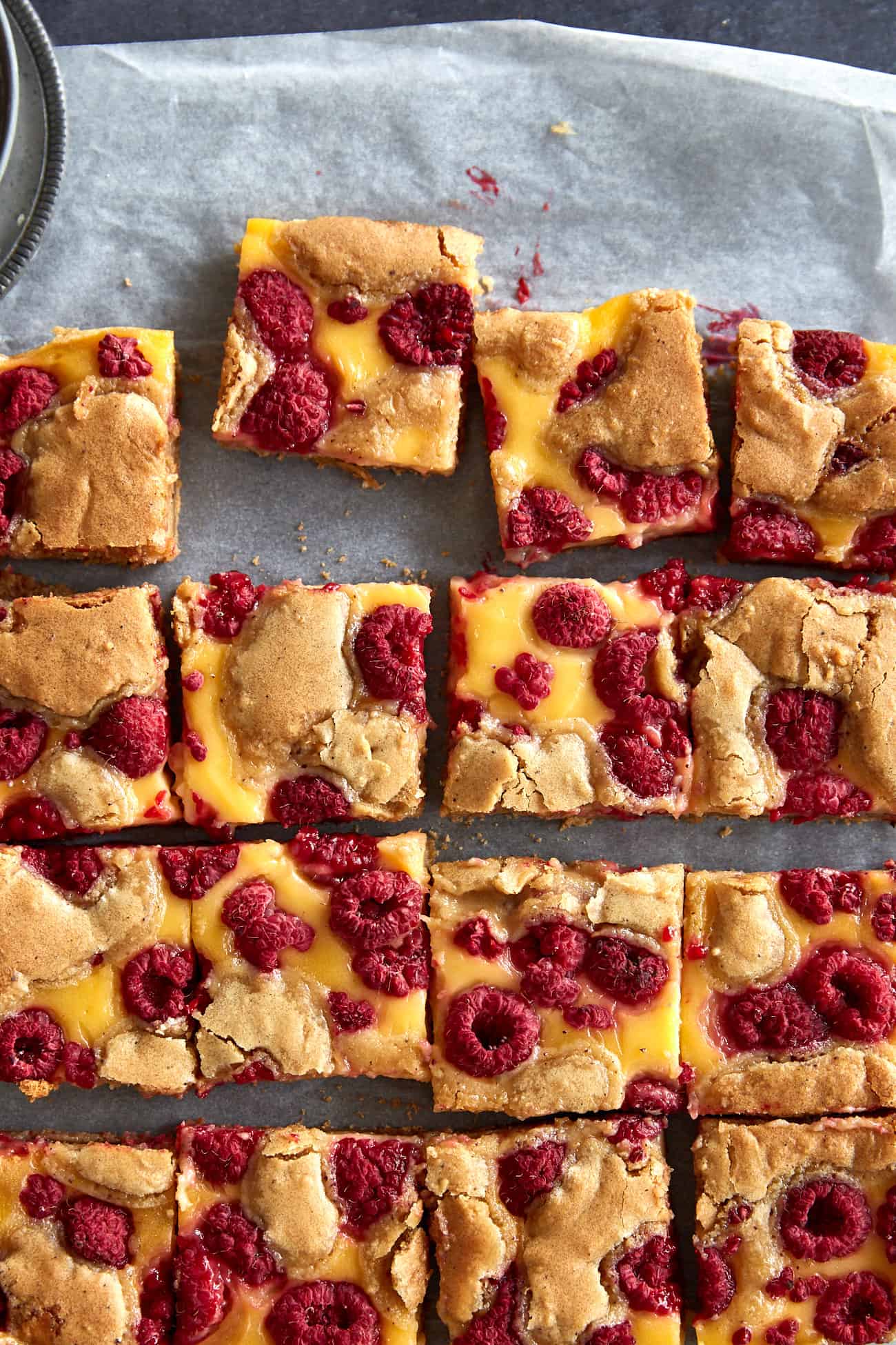 close up of raspberry custard blondies on baking paper