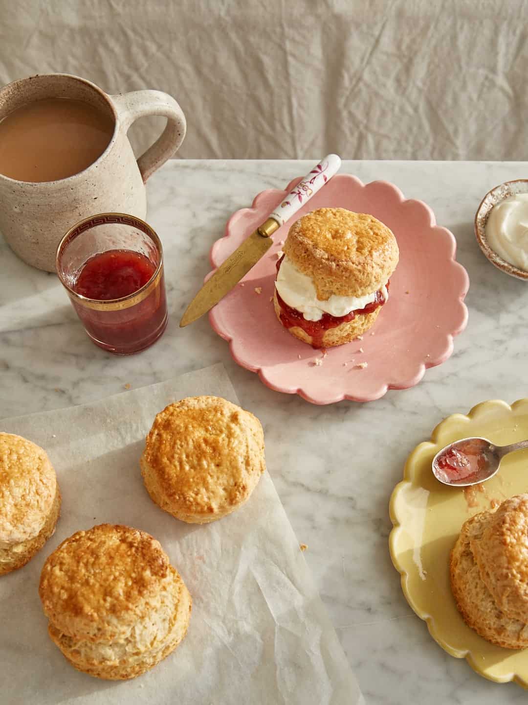 classic scones with clotted cream and strawberry jam and a cup of tea