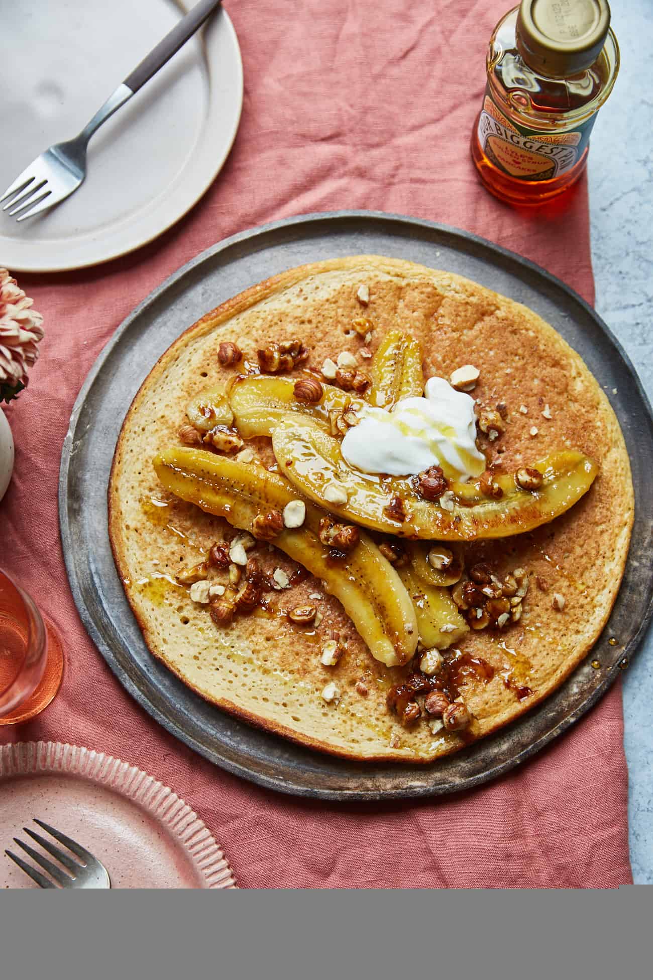 a sharing pancake topped with caramelised bananas and hazelnuts