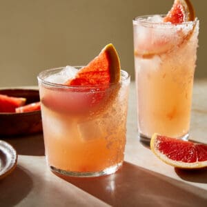 two glasses of Paloma cocktail with salted rim and slice of grapefruit garnish
